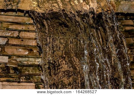 Closeup of water flowing over rock fountain.
