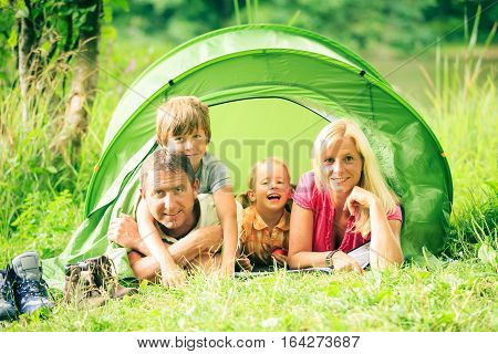 a family is camping by the lakeside