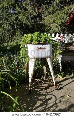 EAST GRAND FORKS, MINNESOTA, Oct 1, 2016: The one minute washing machine serving as a plant container is a vintage washing tub manufactured by One-Minute Laundry Div, Kellogg, Iowa.