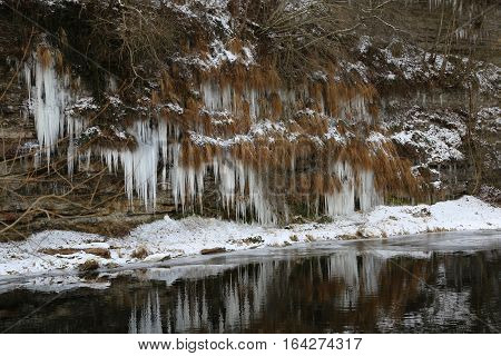 Jagst in the winter / Icicles hang from the bluff to the river.