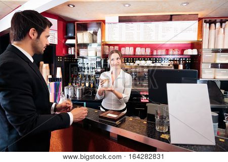 friendly bartender at a cafe, serving coffee-to-go to a customer