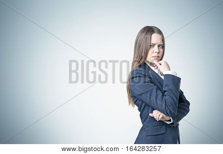 Frowning Businesswoman Near A Gray Wall