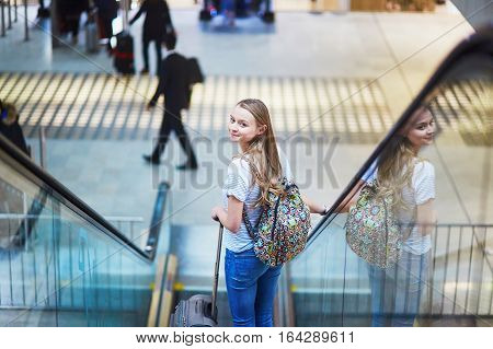 Tourist Girl With Backpack And Carry On Luggage In International Airport, On Escalator