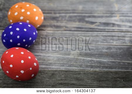 Easter egg colored polka dots lie on wooden background
