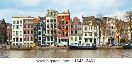 Traditional old buildings, canal and boat in Amsterdam, the Netherlands
