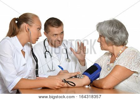 man and woman doctors with patient measuring preasure