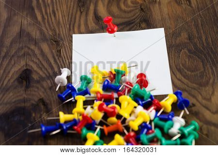 Various Color Thumbtacks And Note On Distressed Wood