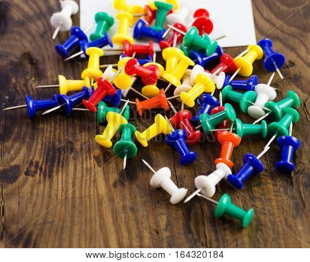 Various Color Thumbtacks And Note On Distressed Wood