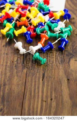 Various Color Thumbtacks And Note On Distressed Wood