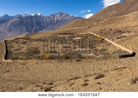 destroyed house enclosed by a stone wall in the Himalayas Nepal