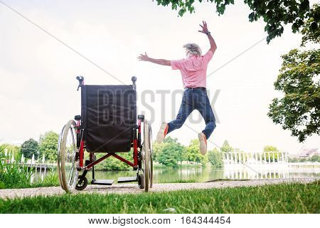 Senior man jumping up from his wheelchair