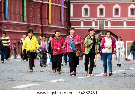 MOSCOW - SEPTEMBER 22 2015: Group of chinese tourists walking on the Red Square. This place is considered as the most popular sightseeng in Russia.