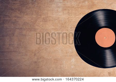 vintage audiophile and musiclover set; vinyl musical disc on wooden background;