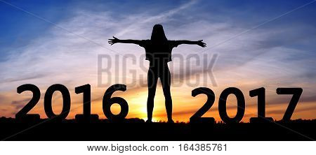 Silhouette young woman jumping on the sea and 2017 years while celebrating new EAP, 2017, happy girl. silhouette of girl at sunset, jumping on the background of sunset