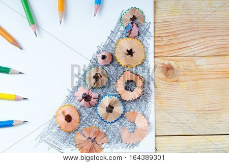 Pencil sharpener shavings on the white paper. Back to school. Copy space.