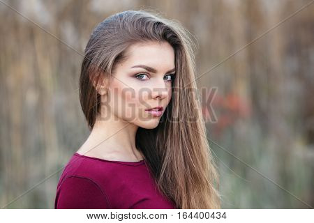 Portrait of pensive sad lonely innocent Caucasian Russian blonde young beautiful woman girl with long hair outside looking in camera autumn fall summer shoot