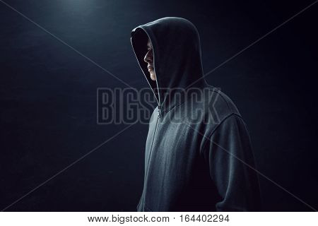 Unknown man standing alone in dark room