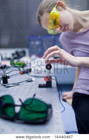 cientista fêmea fazendo pesquisas em um laboratório de óptica quântica (imagem de cor em tons)