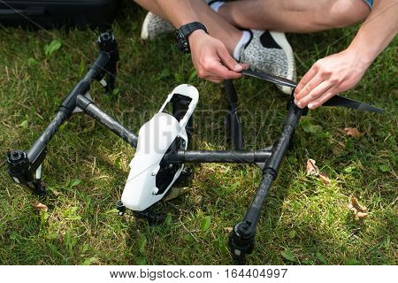 Man Tightening Drone Propeller In Nature