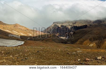 Beautiful scenery slopes of the volcano Mutnovsky with clouds.