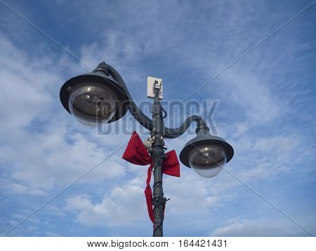 double street lamp decorated with a red ribbon for christmas