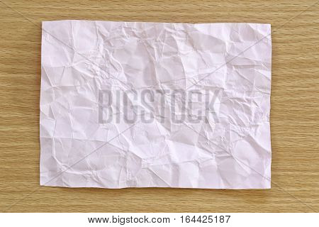 Pink notepad paper crumpled of empty and copy space on wooden backgroundYou can input the message text in picture.