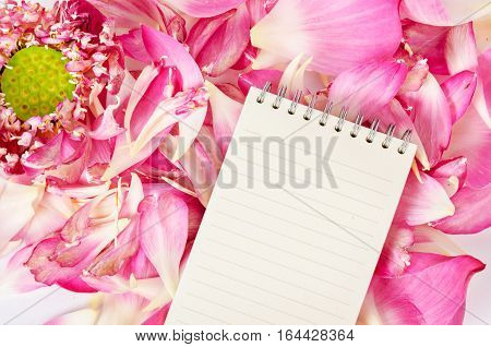 Open blank diary on blooming pink lotus flower background ready for your text.