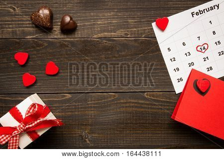 Valentine's day background with copy space. Valentine's Day card, gift box and chocolate on the wooden texture table.