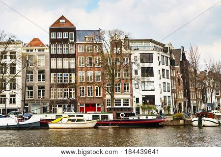Traditional old buildings, canal and boat in Amsterdam, the Netherlands