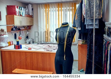 Tailor dummy with measuring tapes in fashion studio