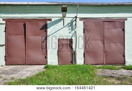Two brown door and a door in the wall.