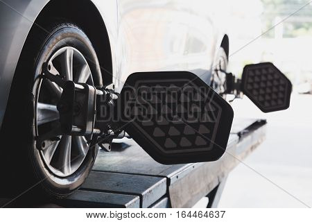 Car on stand with sensors on wheels for wheels alignment camber check in workshop of Service station