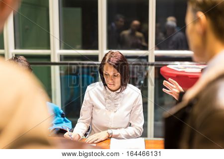 Female personal assistant working at registration desk at corporate event. Business and entrepreneurship concept.