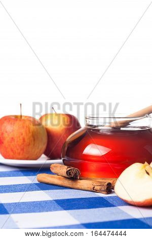 Honey in a jar, cinammon sticks and apples