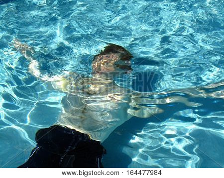 man swimming in a swimming pool underwater
