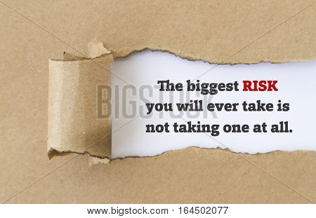 The biggest risk you will ever take is not taking one at all message written under torn paper.