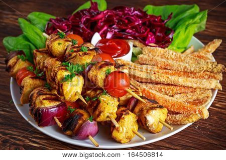 Chicken skewers marinated in turmeric yogurt served with sweet potato and vegetables.