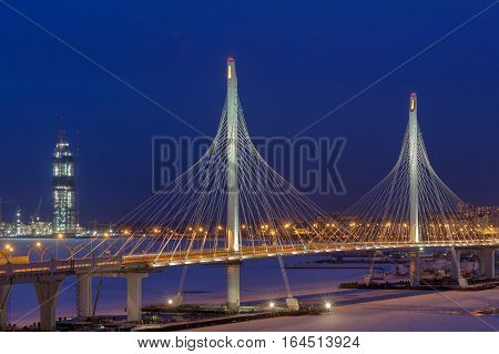Saint-Petersburg Russia - January 3 2017: A highway crosses frozen river cable bridge at night light in the winter.