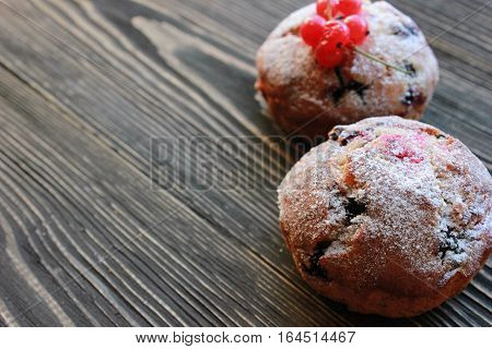 muffin with berries on a wooden table. fresh berries and sweet pastries on the board