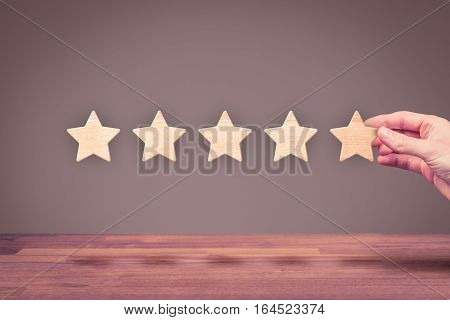 Increase rating, evaluation and classification concept. Businessman represented by his hand add fifth star.