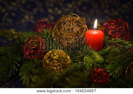 Christmas Decoration with gold and red spheres and a red candle with pines.