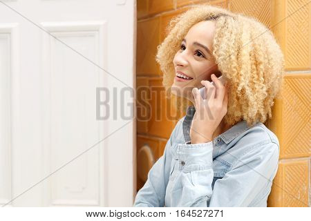 Cheerful girl talking on a cell phone. Young smiling girl talking on the phone