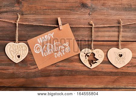 Wooden hearts on rope. Greeting card and clothespin. Handmade congratulation on Valentine's Day.