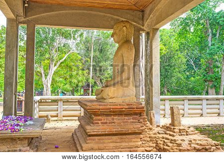 The Samadhi Buddha Statue in pose of meditation is the place of veneration surrounded by ancient ruins and greenery of Mahamevnawa Park Anuradhapura Sri Lanka.