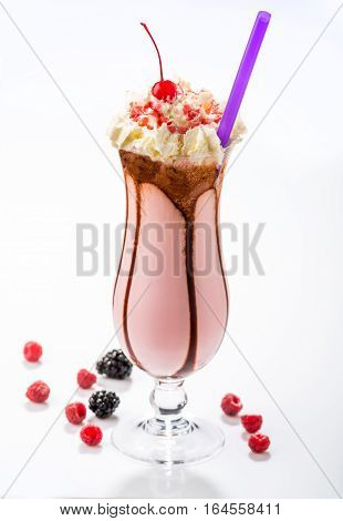 Milkshakes with black currant, cherry, raspberry in glass on the background of wooden boards