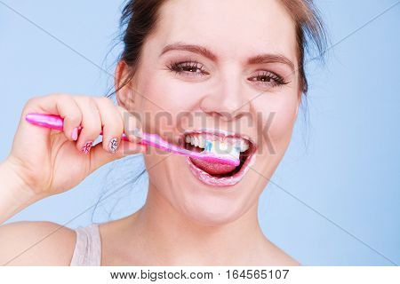 Woman brushing cleaning teeth. Girl with toothbrush. Oral hygiene. Blue background