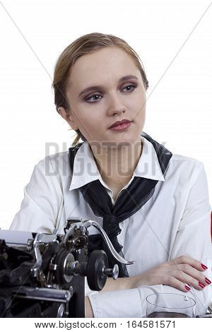Young girl typist with an old typewriter on a white background