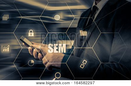SEM-Search Engine Marketing. Business Strategy Concept. The businessman shakes his finger on a virtual screen