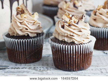 Chocolate cupcake with chocolate mousse cream icing on grunge white wooden background