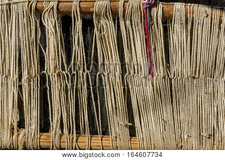 Detail of old traditional weaving loom and shuttle on the warp. Weaving loom for homemade on vintage background.